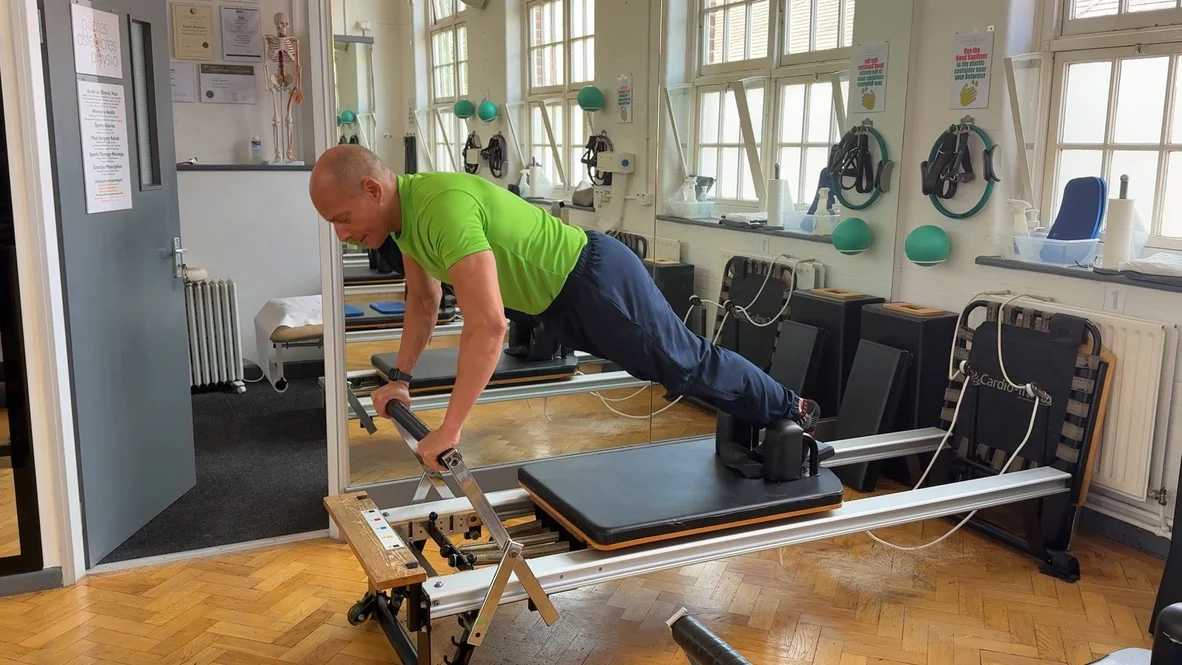 Long stretch press-up on the Reformer, demonstrating control under load, at Applied Pilates St Albans