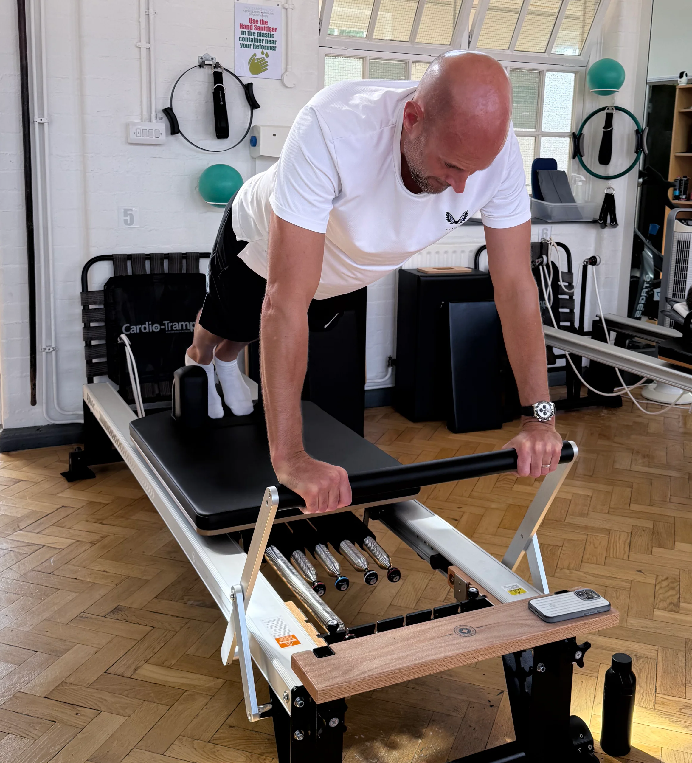 Athlete performing loaded plank work on the Reformer during sports injury rehabilitation at Applied Pilates, St Albans