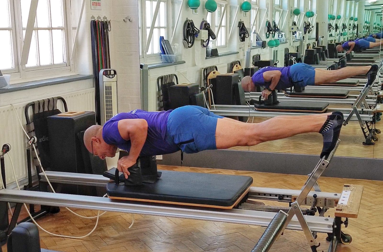 Full plank held on the Reformer carriage in the apparatus studio at Applied Pilates, London Colney, St Albans