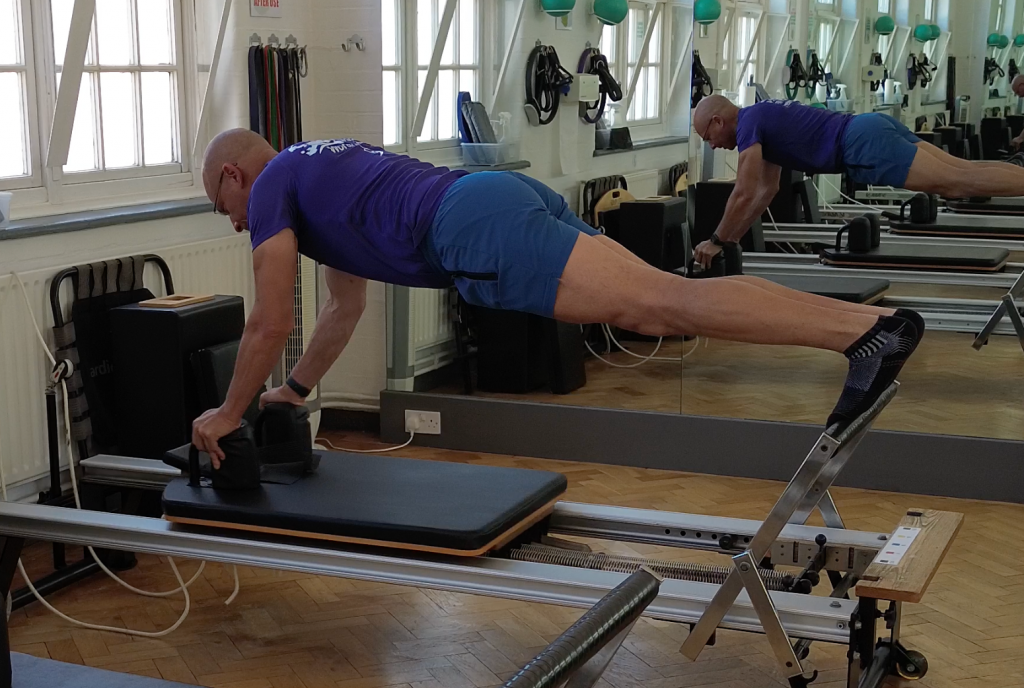 Reverse plank on the reformer working the postural chain at Applied Pilates, St Albans
