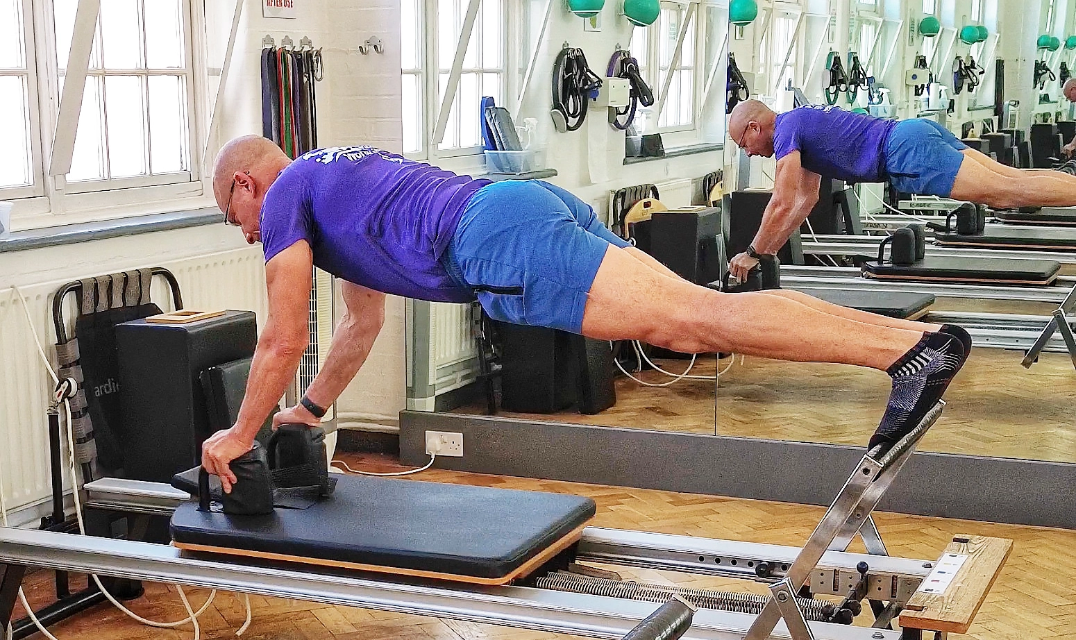 Reverse plank on the reformer working the postural chain at Applied Pilates, St Albans